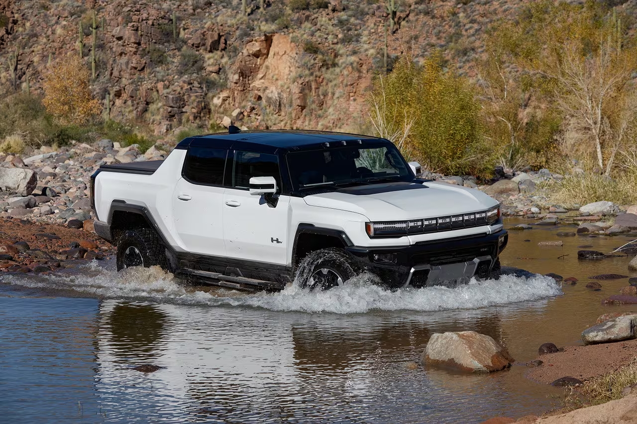 2024 GMC Hummer EV crossing a small body of shallow water