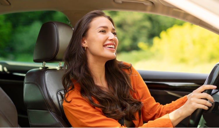 A lady happily driving her new car